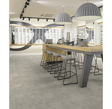 Moderne Raumgestaltung mit großformatigen grauen Bodenfliesen in Steinoptik, einem hohen Holztisch mit Barhockern und großen Pendelleuchten.