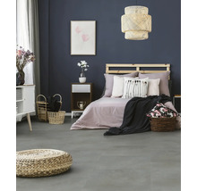 Modernes Schlafzimmer mit dunkelblauer Wand, grauem Boden in Steinoptik, Holzbett mit Paletten-Kopfteil und geflochtener Hängeleuchte.
