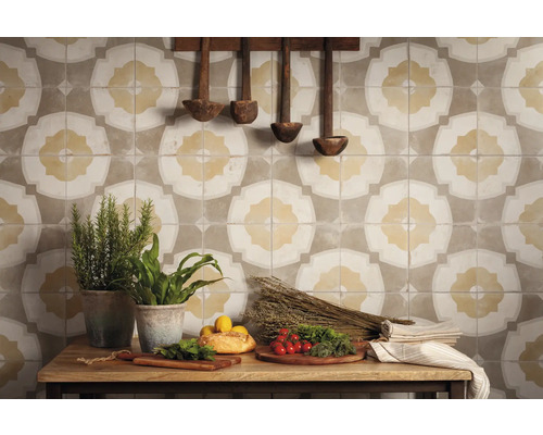 Dekorative Wandfliesen mit floralem Muster, kombiniert mit rustikalen Holzlöffeln und frischen Zutaten auf einem Holztisch.