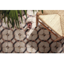 Dekorfliesen mit geometrischem Muster, kombiniert mit Stuhl und Zimmerpflanze für ein stilvolles Raumdesign.