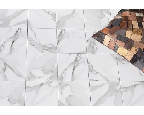 Fliesen mit Marmoroptik auf dem Boden, ergänzt durch ein dekoratives Kissen