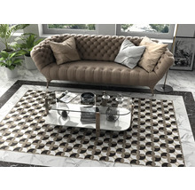 Wohnzimmer mit Sofa, Couchtisch und gemustertem Teppich