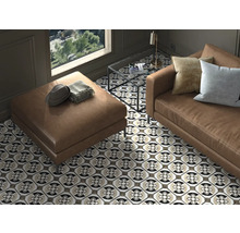 Wohnzimmer mit Sofa, Hocker und gemusterten Fliesen