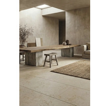 Innenraum mit Esstisch aus Holz auf Betonsockel, Hocker und Teppich