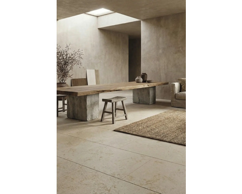 Innenraum mit Esstisch aus Holz auf Betonsockel, Hocker und Teppich