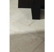 Detailaufnahme von Bodenfliesen und einem dunklen Möbelbein.