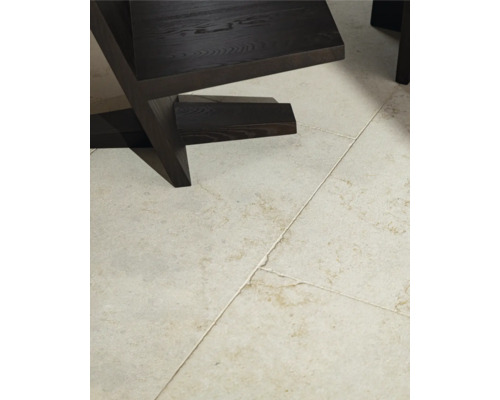 Detailaufnahme eines dunklen Holzstuhls auf einem gefliesten Boden.