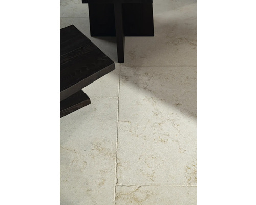 Bodenfliesen aus Naturstein unter einem Tisch