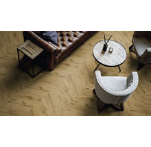 Wohnzimmer mit Fischgrätmuster Laminatboden, Sofa, Tisch und Stühlen.