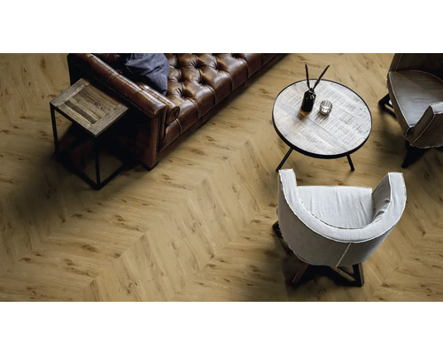 Wohnzimmer mit Fischgrätmuster Laminatboden, Sofa, Tisch und Stühlen.