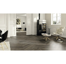 Wohnzimmer mit Fischgrätparkett, Kaminofen und Sesseln für ein stilvolles Ambiente