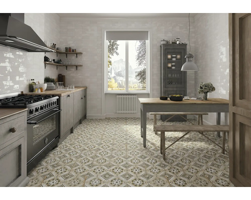 Helle Küche mit Herd, Spüle, Esstisch und gemusterten Bodenfliesen für ein stilvolles Ambiente.