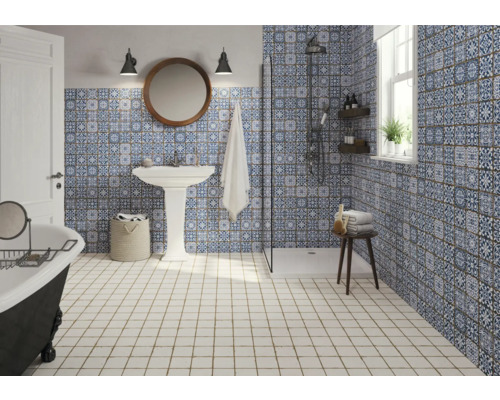 Badezimmer mit Dusche, Waschtisch, Badewanne und blau-weiß gemusterten Fliesen.