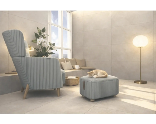 Wohnzimmer mit Sessel, Hocker, Stehlampe und einer Katze, die auf dem Hocker schläft