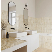 Helles Badezimmer mit beigen vertikalen Wandfliesen, weißen Aufsatzwaschbecken, schwarzen Wandarmaturen und ovalen Spiegeln.