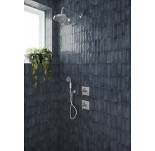Dunkelblaue glänzende Wandfliesen vertikal verlegt in einer Dusche mit Regendusche, Handbrause und Chromarmaturen.