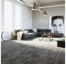 Modernes Wohnzimmer im Loft-Stil mit grauem Bodenbelag in Holzoptik, großem Ecksofa und Sichtbetonwand.