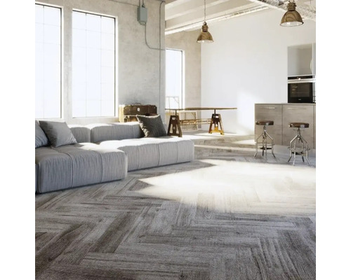 Hell gestalteter Wohnraum im Industriestil mit Bodenbelag in Fischgrätoptik, großem Sofa und Industrie-Leuchten.