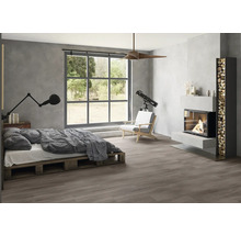 Modernes Schlafzimmer im Industrial Style mit dunklem Boden in Holzoptik, grauen Wänden in Betonoptik, Palettenbett, großem Fenster und Kamin.