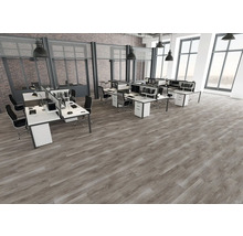 Moderner Büroraum im Industriedesign mit Bodenbelag in Holzoptik, weißen Schreibtischen, schwarzen Stühlen und großen Fenstern.