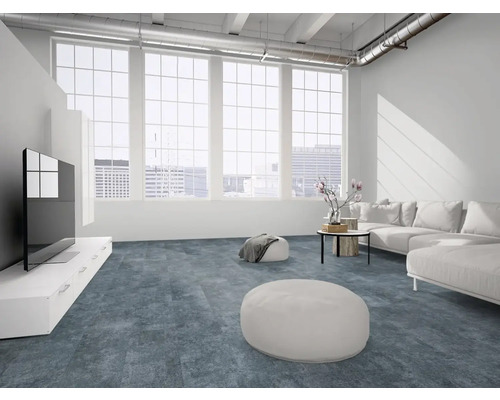 Moderner Wohnraum mit blau-grauem Strukturboden, weißem Sofa, großen Fenstern und industriellem Loft-Stil.