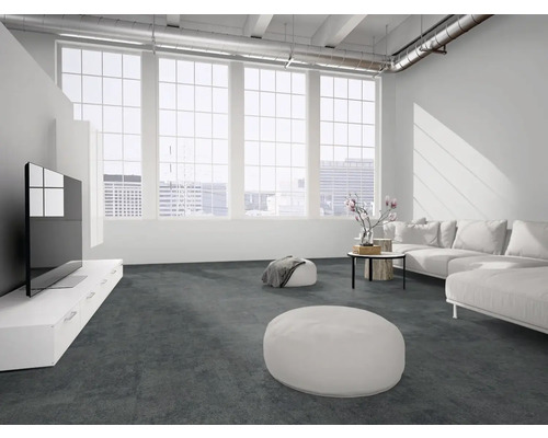 Moderner, heller Wohnraum im Loft-Stil mit dunkelgrauem Boden, weißem Ecksofa, großen Fenstern und sichtbaren Lüftungsrohren.