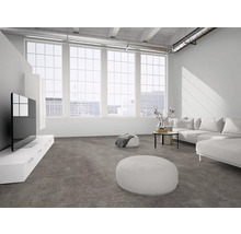 Helles, geräumiges Wohnzimmer im Loft-Stil mit grauem Boden in Betonoptik, großen Fenstern, weißem Sofa und weißem TV-Unterschrank.