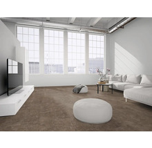 Heller, moderner Wohnraum mit braunem Teppichboden, weißem Sofa, Poufs und großen Fenstern in Loft-Optik.
