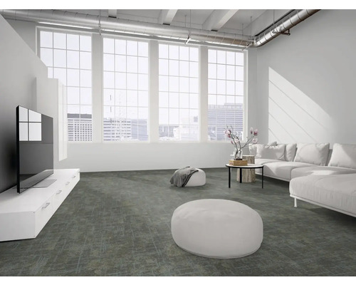 Hell gestaltetes, geräumiges Wohnzimmer im Loft-Stil mit dunkelgrau gemustertem Teppich, weißem Sofa und großen Fenstern.