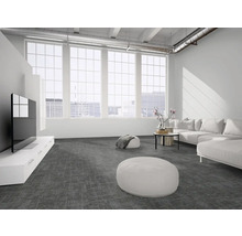 Modernes Wohnzimmer im Loft-Stil mit dunkelgrauem Teppichboden, weißem Ecksofa, hellen Fensterfronten und industriellen Deckenelementen.