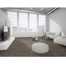 Hellbrauner gemusterter Teppichboden in einem hellen, geräumigen Wohnzimmer im Loft-Stil mit weißem Sofa und großen Fenstern.
