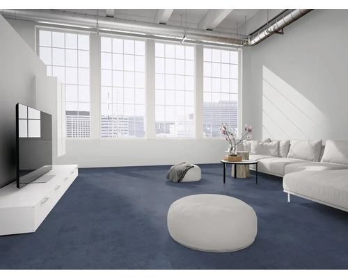 Moderner, heller Wohnraum mit dunkelblauem Teppichboden, weißem Sofa und großen Fenstern im Industriestil.