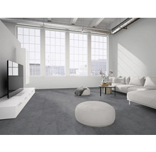 Moderner, heller Wohnraum mit grauem Bodenbelag, weißem Sofa, großem Fernseher auf einem weißen Lowboard und großen Fenstern.