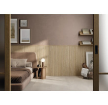 Schlafzimmer mit Wandverkleidung aus vertikalen Holzlamellen im unteren Wandbereich, gepolstertem Bett und Beistelltisch.