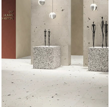 Moderner, heller Ausstellungsraum mit Bodenfliesen und Wandpaneelen in Terrazzo-Optik, quadratischen Sockeln und minimalistischen Skulpturen.