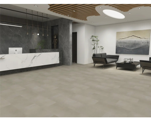 Modern gestalteter Empfangsbereich mit großflächigen, beigen Bodenfliesen, einer Marmor-Optik-Theke und einer Sitzecke mit dunklen Sofas.