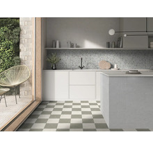 Helle moderne Küche mit schachbrettartigen Bodenfliesen, weißen Schränken, gesprenkeltem Fliesenspiegel und gefliester Kücheninsel.