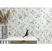 Wandfliesen mit botanischem Blattmuster in einer hellen Raumsituation mit Glasvase und Holzfigur auf einer Kommode.