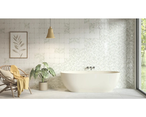 Helles Badezimmer mit freistehender Badewanne und quadratischen Wandfliesen mit floralen und schlichten Mustern.