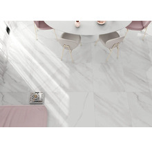 Großformatige Bodenfliesen in weißer Marmoroptik in einem hellen, modernen Esszimmer mit rundem Tisch und Stühlen.