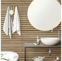 Badezimmer mit horizontalen Wandpaneelen in Holzoptik, einem runden Spiegel, einem weißen Aufsatzwaschbecken und Handtüchern an der Wand.