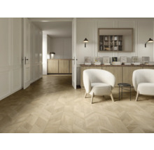 Heller Wohnraum mit Parkettboden im Fischgrätmuster, zwei weißen Sesseln, Sideboard aus Holz und wandmontierten Lampen.
