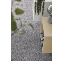 Strukturierter grauer Teppichboden in einem hellen, modern eingerichteten Raum mit Beistelltisch und Pflanze.