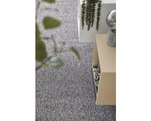 Strukturierter grauer Teppichboden in einem hellen, modern eingerichteten Raum mit Beistelltisch und Pflanze.