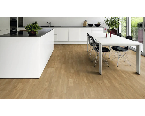 Moderne helle Küche und Essbereich mit weißen Möbeln und einem Parkettboden in Schiffsboden-Optik.