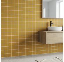 Modernes Badezimmer mit ockerfarbenen quadratischen Wandfliesen, weißem Aufsatzwaschbecken auf hellem Holz-Waschtischunterschrank.