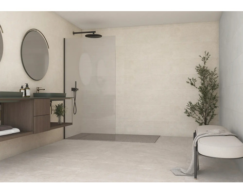 Helles Badezimmer mit begehbarer Dusche, schwarzer Armatur, Waschtisch aus dunklem Holz, rundem Spiegel und hellen Fliesen an Wand und Boden.