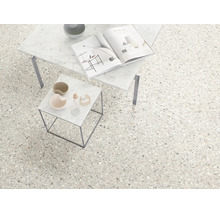Bodenfliesen in Terrazzo-Optik in einem hellen, modern gestalteten Raum mit zwei Beistelltischen aus Marmor.