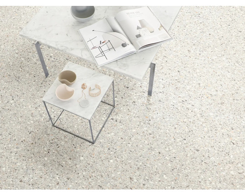 Bodenfliesen in Terrazzo-Optik in einem hellen, modern gestalteten Raum mit zwei Beistelltischen aus Marmor.