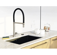 Moderne Küche mit schwarzer Einbauspüle, Armatur mit flexiblem Auslauf, Arbeitsplatte in Marmoroptik und Holzunterschränken.